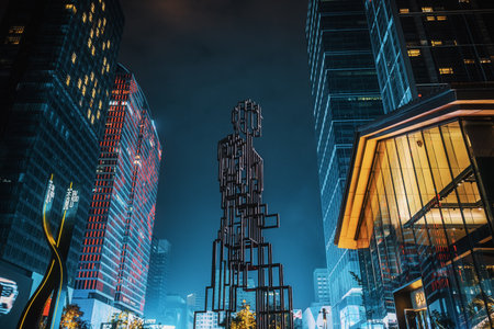 Chengdu, Sichuan province, China - Oct 2, 2022: Illuminated skyscrapers and metallic statue at night in Taikooli commercial area, downtown Chengduのeditorial素材