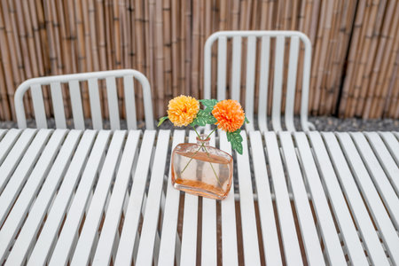 Outdoors white steel table and chairs on a wooden terrace in summerの写真素材