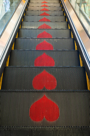 Unique escalator steps beautifully adorned with heart shapes, creating a vibrant and playful visual effectの写真素材