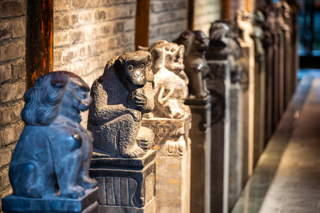 Visitors in DuJiangYan, Sichuan province, marvel at a stunning collection of stone sculptures lining the historic walkway. Each figure, meticulously carved from stone, represents various animals, showcasing exquisite detailing and craftsmanship. The sculptures reflect the regions rich cultural heritage and artistic tradition. Light filters through the space, illuminating the textures of the stones and creating a serene atmosphere.の写真素材