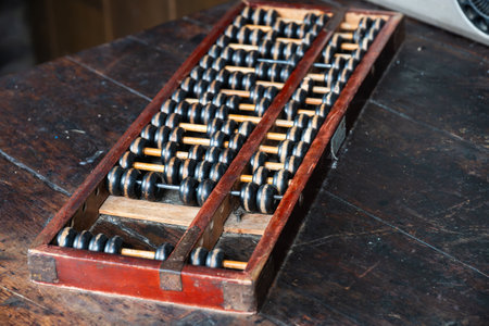 A well-preserved vintage abacus sits on a rustic wooden table, highlighting its traditional design...