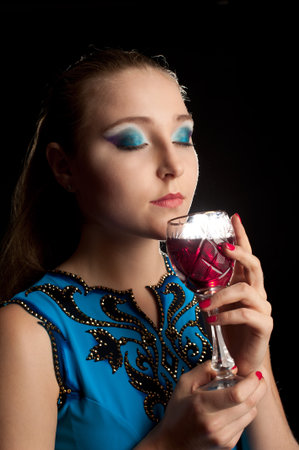 Portrait of a beautiful young woman with a glass of wineの写真素材
