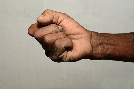 Male hand stranglehold sign on gray backgroundの写真素材