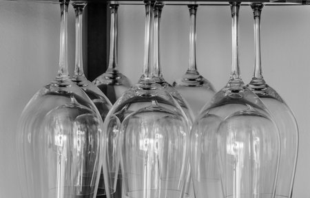 Classic wine glasses hanging from a barの写真素材