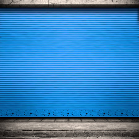 Painted corrugated metal door with conrete wall and ground. 