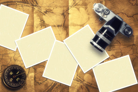 Blank card and vintage camera with old compass on old map background 