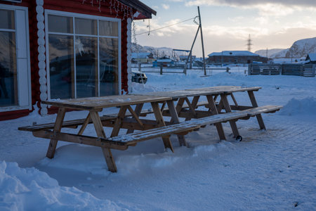 Teriberka, Russia, February, 2019: chairs in front of the cluster of red Russian residential houses in Teriberka. Winter, Murmansk.のeditorial素材