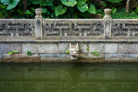 The stone dragon head on the wall in the garden.の写真素材