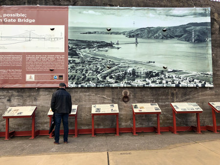 San Francisco, America, March, 2018. A man is reading the story of the Golden Gate Bridge in the daytime. It's a suspension bridge spanning the Golden Gate.のeditorial素材