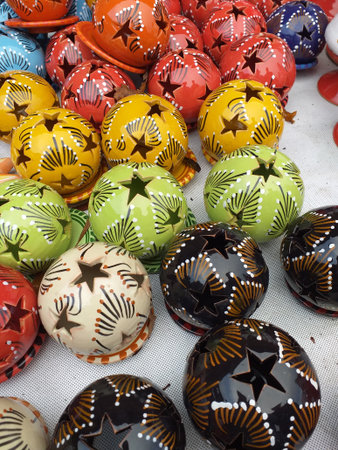 A display of different coloured tea lights, round balls with star shaped patternsの写真素材