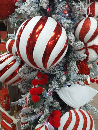 A collection of Red and White Christmas Baubles against a silver coloured christmas treeの写真素材