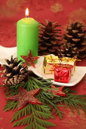 Christmas candle and decorations on a red background.の写真素材