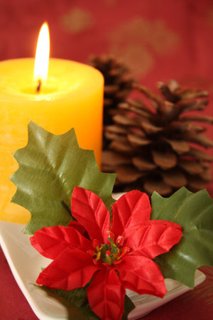 Christmas candle and decorations on a red background.の写真素材