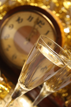 Two glasses of champagne and clock.の写真素材