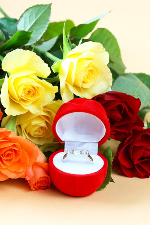 Silver ring in a red box and flowers の写真素材