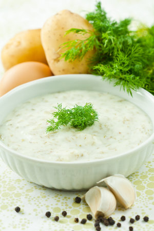 Dill soup with egg and potatoes in a white bowl の写真素材