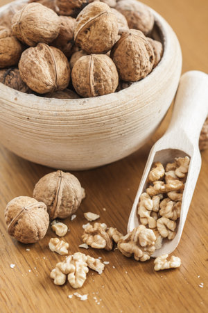 Bowl full of walnuts on a wood background の写真素材