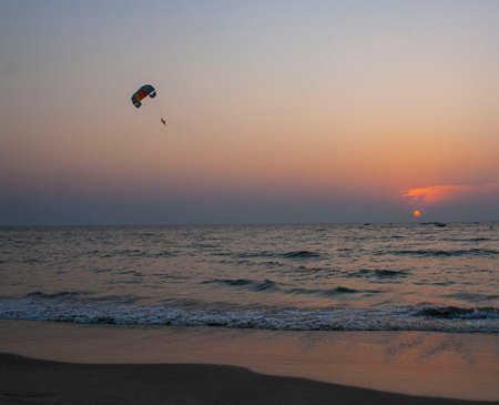 A para glider silhouette at sunset in Goa, India.の写真素材