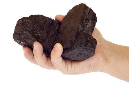 coal, carbon nuggets in hand isolated on white backgroundの写真素材