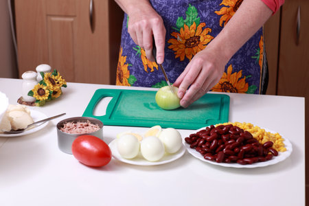 woman preparing onion in the kitchen at home の写真素材
