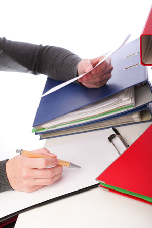 businesswoman - woman hand pen. Pile of folders with old documents and bills. Isolated on white backgroundの写真素材