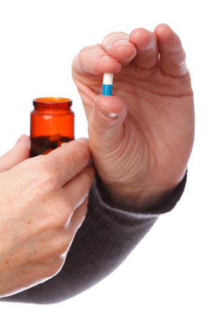blue - white pills in woman hand isolated の写真素材