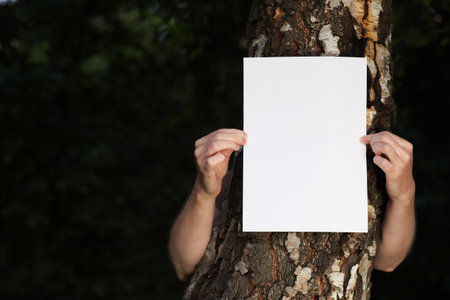 woman with blank paper outdoor treeの写真素材