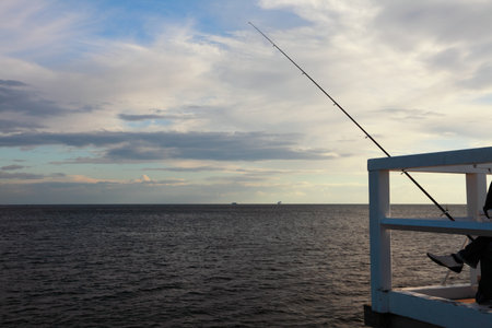  fishing rod, sea and sky at the pier, jettyの写真素材