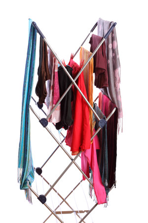 colorful clothes hanged for drying after laundry clothes airer, clothes dryer isolated on whiteの写真素材