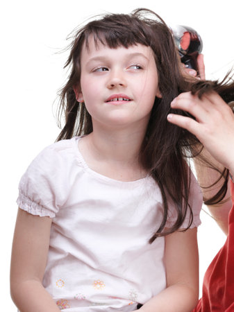 woman and Little girl dries hair, daughter isolated on whiteの写真素材