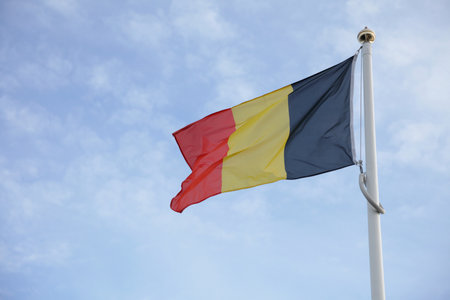 Belgium flag of on blue sky backgroundの写真素材