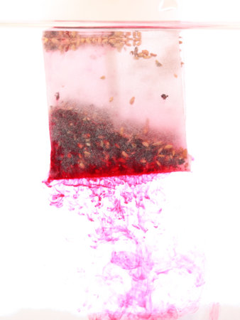 red Teabag in hot water in white backgroundの写真素材