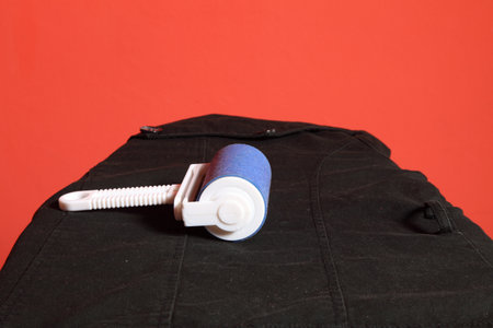 blue cleaner dust with lint roller red backgroundの写真素材