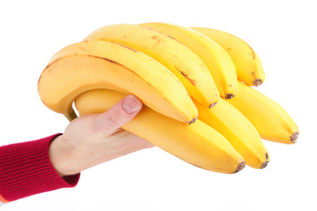 yellow bunch bananas in woman hand isolated on white background の写真素材