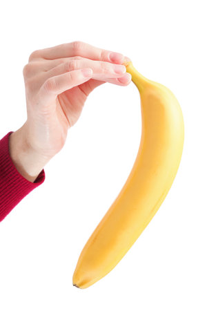 yellow banana in woman hand isolated on white background の写真素材