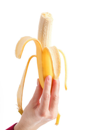 yellow banana in woman hand isolated on white background の写真素材