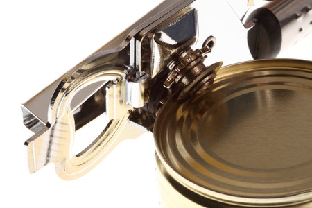 Tin opener opening a can of food isolated on white の写真素材