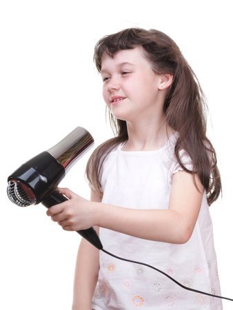 little girl posing with hair dryer isolated on whiteの写真素材