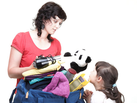 woman and baby daughter crammed full of clothes and blue shoulder bag isolated on whiteの写真素材