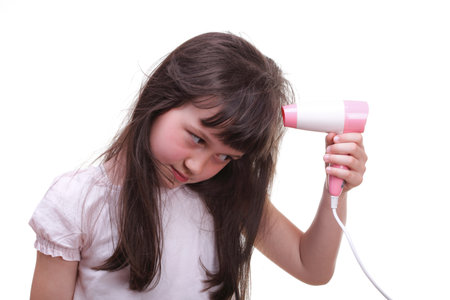 Pretty girl drying her hair hairdryer isolated on whiteの写真素材