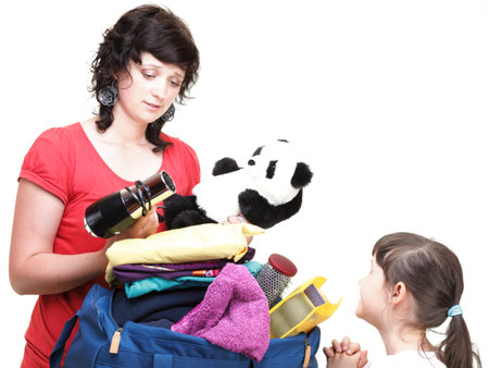 woman and baby daughter crammed full of clothes and blue shoulder bag isolated on whiteの写真素材
