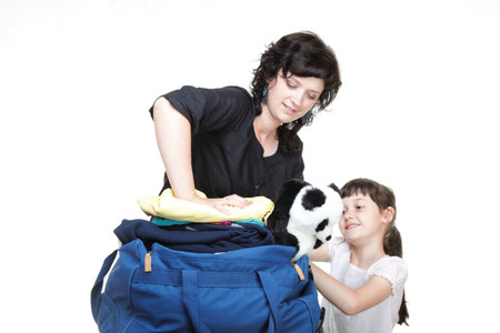 woman and baby daughter crammed full of clothes and blue shoulder bag isolated on whiteの写真素材