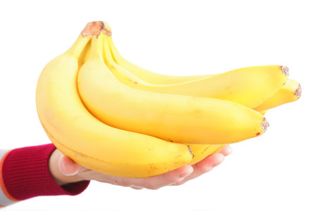yellow bunch bananas in woman hand isolated on white background の写真素材