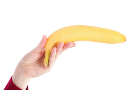 yellow banana in woman hand isolated on white background の写真素材