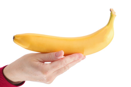 yellow banana in woman hand isolated on white background の写真素材
