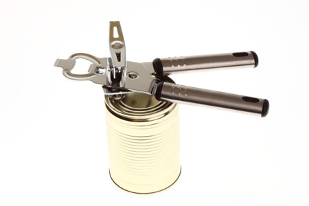 Tin opener opening a can of food isolated on white の写真素材