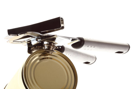 Tin opener opening a can of food isolated on white の写真素材