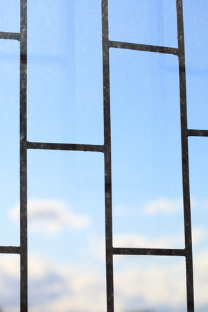 Metallic bars with blue sky background storm, tempest, clouded over freedomの写真素材