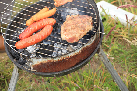Flames grilling a steak on the BBQ bonfire, campfire summerの写真素材