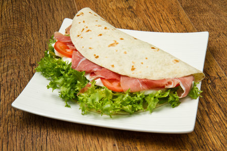 italian piadina with ham, fresh salad and mozzarella cheeseの写真素材